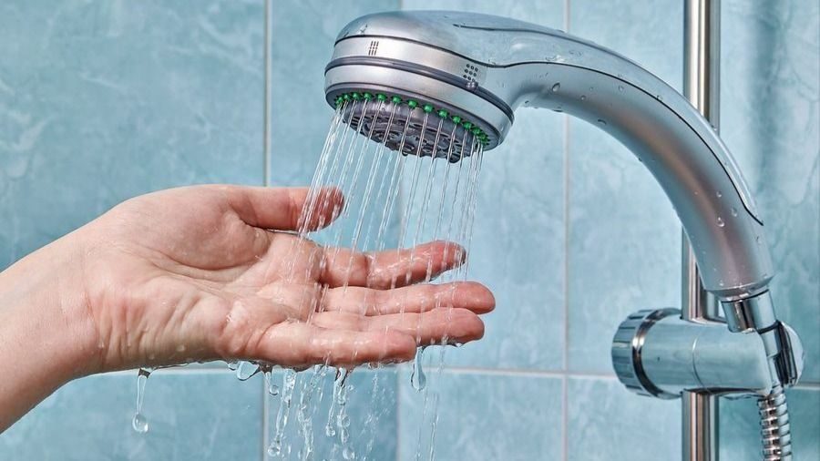 Shower head spraying water in a bathroom